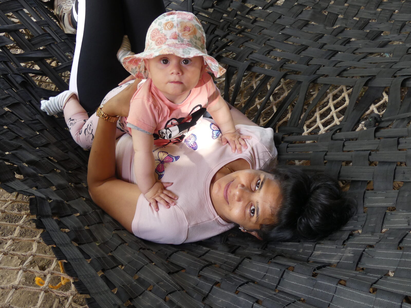 Erwachsene mit Kleinkind auf dem Schoß in einer Schaukel.