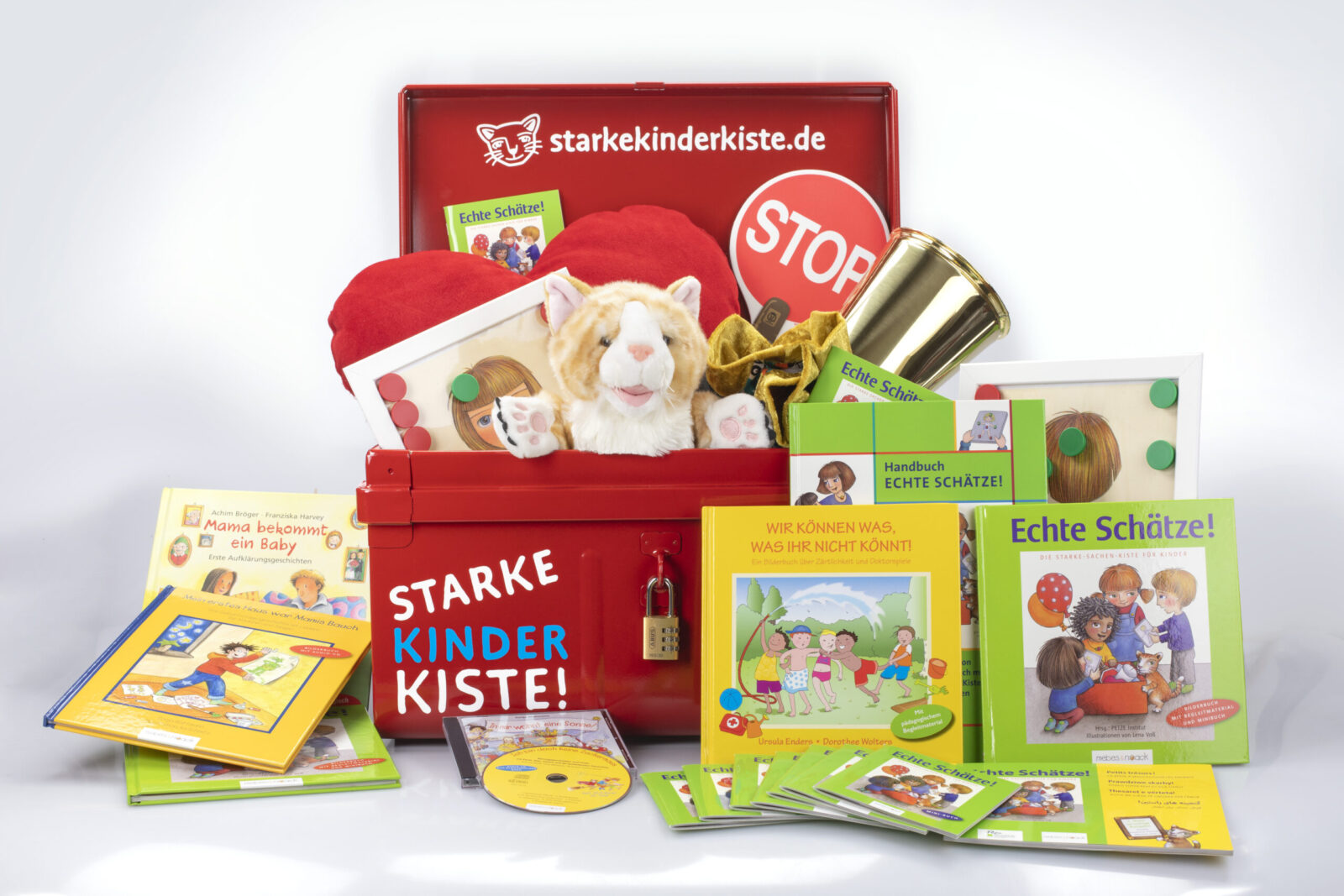 Ein roter Koffer mit der Aufschrift „Starke Kinder Kiste!“ enthält verschiedene Materialien zur Prävention und Stärkung von Kindern. Zu sehen sind Bücher, eine Plüschkatze, ein Stop-Schild, CDs und weitere pädagogische Materialien. Der Koffer ist Teil eines Programms zur Förderung von Selbstbewusstsein und Schutz von Kindern.