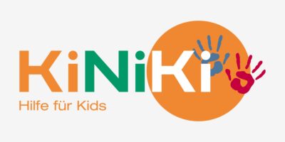 Das Bild zeigt das Logo von KiNiKi, einer Organisation, die Hilfe für Kinder anbietet. Das Logo besteht aus dem Schriftzug "KiNiKi" in orange und grün, wobei das "K" und das "i" durch einen orangefarbenen Kreis hervorgehoben werden. Innerhalb des Kreises sind zwei Handabdrücke, einer in blau und einer in rot, zu sehen, die spielerisch auf die Unterstützung und Förderung von Kindern hinweisen. Unter dem Logo steht der Slogan "Hilfe für Kids" in orangefarbener Schrift.