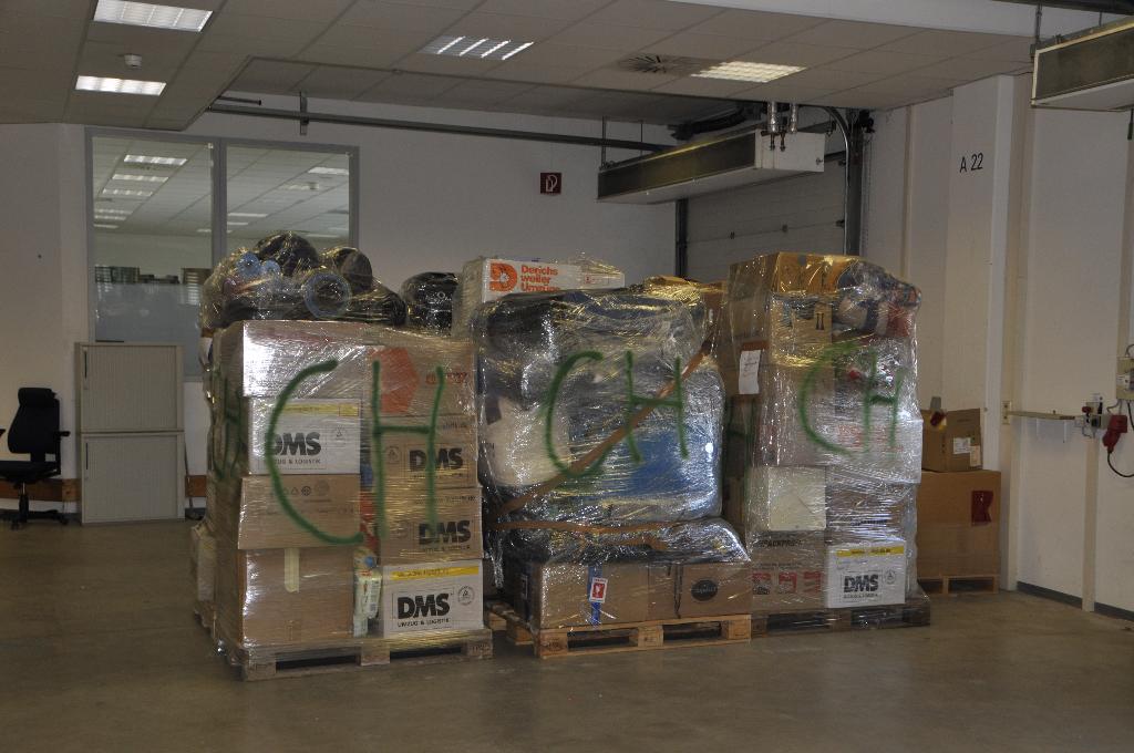 Mehrere Paletten mit verpackten Waren stehen in einem Lagerraum. Die Paletten sind mit verschiedenen Produkten beladen und sorgfältig verpackt. Im Hintergrund sind weitere Lagerregale und Materialien zu sehen.